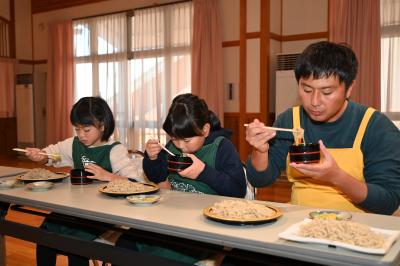 作ったそばを親子で食べている写真