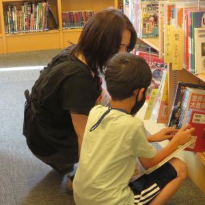 図書館内で本を探す司書と参加者