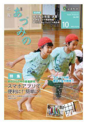 広報あづみの10月号の表紙。園舎建て替えのため、隣地の多目的ホールで行われた三郷西武認定こども園の運動会で、年長児の男女が走り出しています。