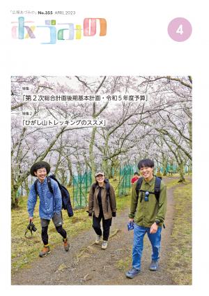 広報あづみの4月号表紙　桜が満開の光城山にトレッキングに来た男女3人の笑顔が写っています